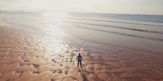 无人机拍摄的运动女子站在岸上的视频