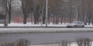 汽车在城市街道上行驶。冬天的时候，雪花飘落。贝尔格莱德城