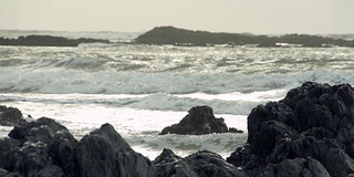 阳光在暴风雨的岩石海滩上