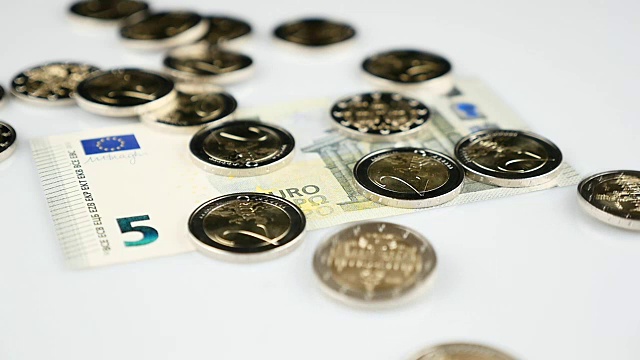两枚欧元硬币落在钞票上