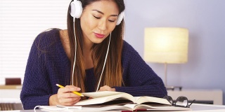 一个中国女人一边听音乐一边做作业