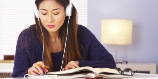 亚洲女人一边听音乐一边做作业