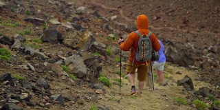 徒步旅行者沿着陡峭的山路走下去