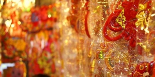 商店里挂着春节装饰品。五颜六色的红、金、字装饰挂件和纸周围