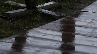 秋天，雨滴落在废弃的游乐园的木路上视频素材模板下载
