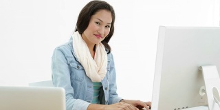 亚洲女性使用笔记本电脑和电脑在办公桌前工作