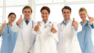 自信的医疗团队看着摄像机，竖起大拇指视频素材模板下载