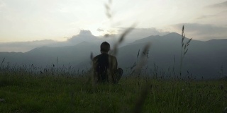 年轻的男子坐在山上观看全景视频高清