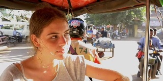 年轻的女孩独自骑着嘟嘟车在亚洲旅行