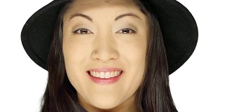 一个漂亮的女人戴着帽子，微笑着，在一个白色的工作室背景