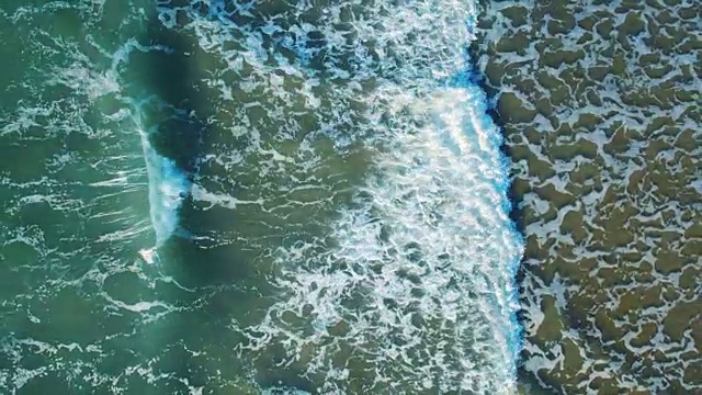 无人机拍摄的平静的海浪拍打海岸的画面