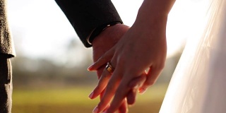 婚礼夫妇牵手在日落背景拍摄慢动作近距离