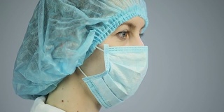女外科医生用悲伤的眼神看着镜头，准备