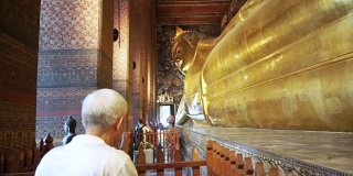 亚洲男子高级游客参观卧佛，卧佛佛像在曼谷，泰国