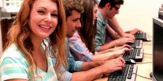 计算机课上，快乐的学生对着镜头微笑