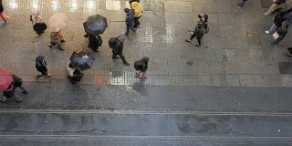 土耳其伊斯坦布尔，Beyoglu，一群人撑着雨伞在istikal街上行走。