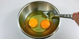 在不锈钢碗里打鸡蛋