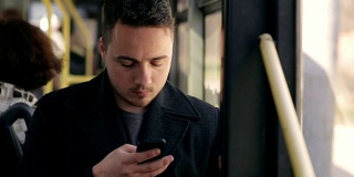 一个在公车上打电话的男人。阅读电子邮件。短信消息