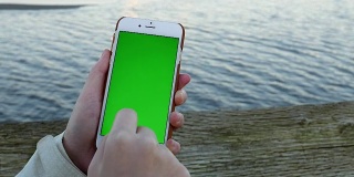 女子手持绿色屏幕显示手机智能手机