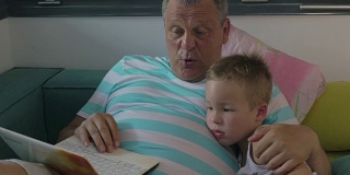 孩子和爷爷在家里使用笔记本电脑