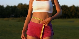 女运动员自然测量腰围。