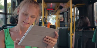 公交车上拿着平板电脑的微笑女人
