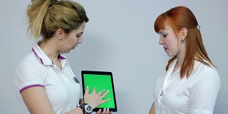 医生在平板电脑，绿色屏幕上与患者讨论结果
