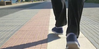 男人们的脚在度假小镇的人行道上奔跑