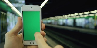 一名男子在地铁站使用手机绿屏