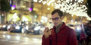 男人在城市里用智能手机上的应用程序发短信