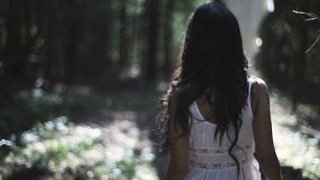 受惊的年轻女子走在森林里视频素材模板下载