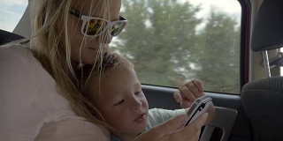 孩子在车里玩妈妈的智能手机