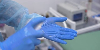 医生用喷雾消毒乳胶手套。医学与健康理念