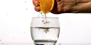 用手把橙汁挤进玻璃杯