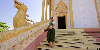 美丽的亚洲女孩在寺庙里表演椰子民间舞蹈