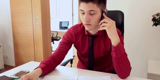 年轻男性办公室职员使用智能手机聊天