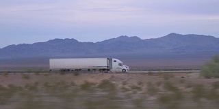 特写:货运半挂车在空旷的公路上行驶和运输货物