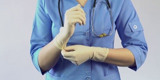 胃肠病学家戴上橡胶手套，为病人检查做准备