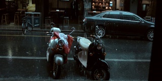 在上海永康路，摩托车在雨中停在路上。