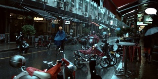 下着雨的上海永康路，人们走路，停着摩托车