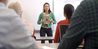 女性亚洲教师平板电脑上成人教育课
