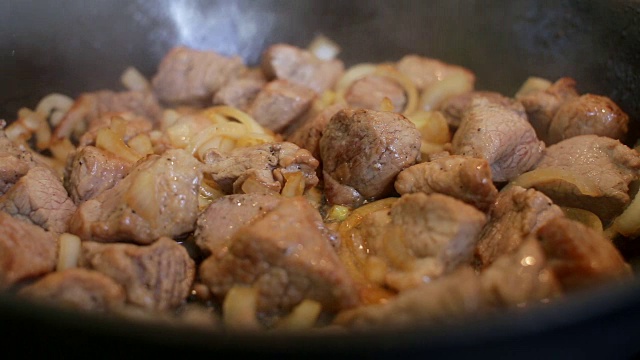 厨师用平底锅煮洋葱和肉