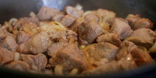厨师用平底锅煮洋葱和肉