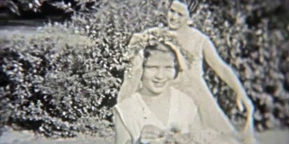1937年:年轻的新娘试穿她的礼服，她的仆人帮忙。
