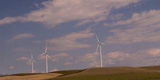 在蒙大拿的风电场上的风力涡轮机的慢镜头驾驶