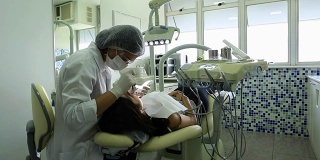 牙医正在检查病人的牙齿。妇女工作的病人的牙痛和牙科保健卫生