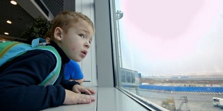 母亲和小儿子看着窗外的机场