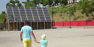 父亲给儿子看太阳能电池板