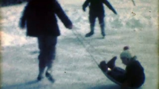 1957年:孩子们在冬季滑雪橇上滑冰。视频素材模板下载