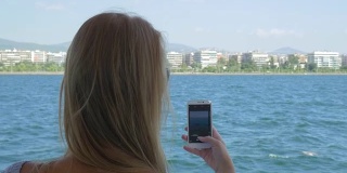 船上有个女人在用手机拍海上照片